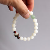White bodhi seed bracelet with carved flower and jade accents - held by model